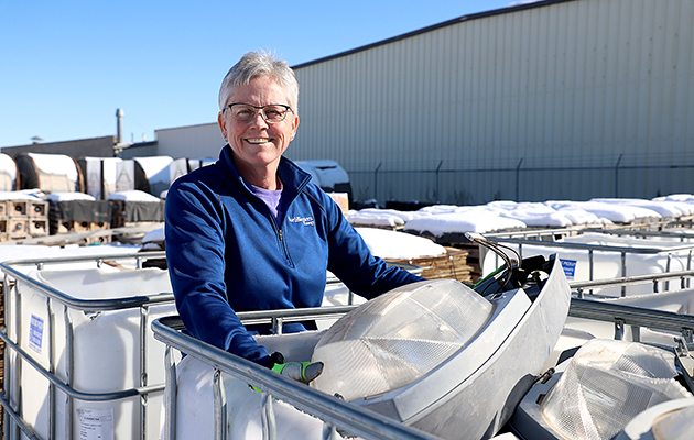 A NorthWestern Energy employee holds an old HPS streetlight that is on its way to recycling.